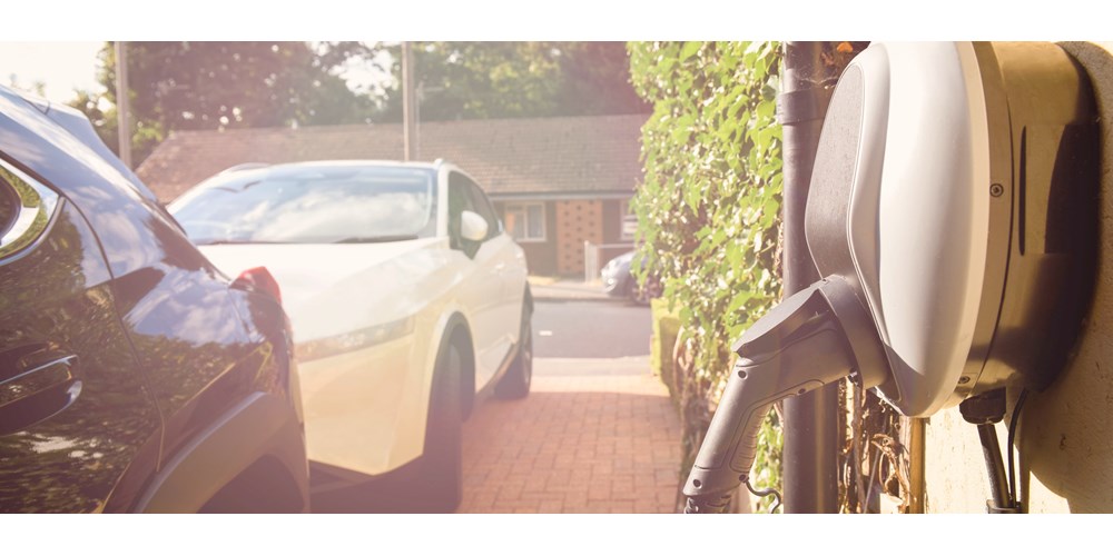 car parked on driveway plugged into wall socket