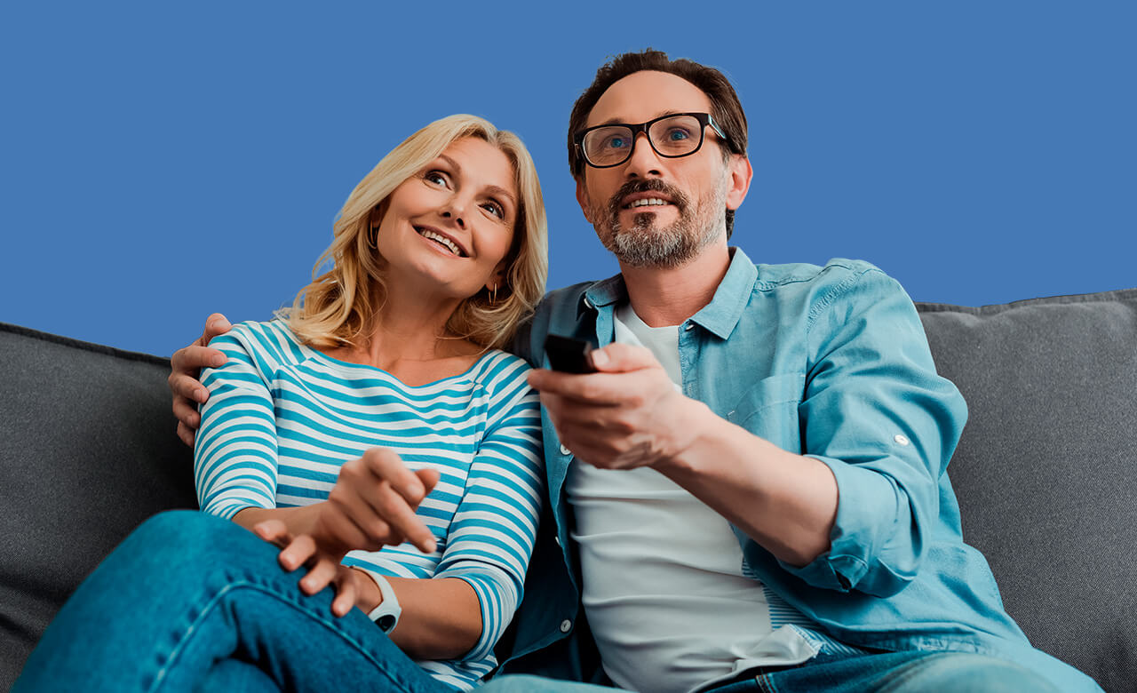 Woman smiling with headset wearing a blue jumper, on blue blackground