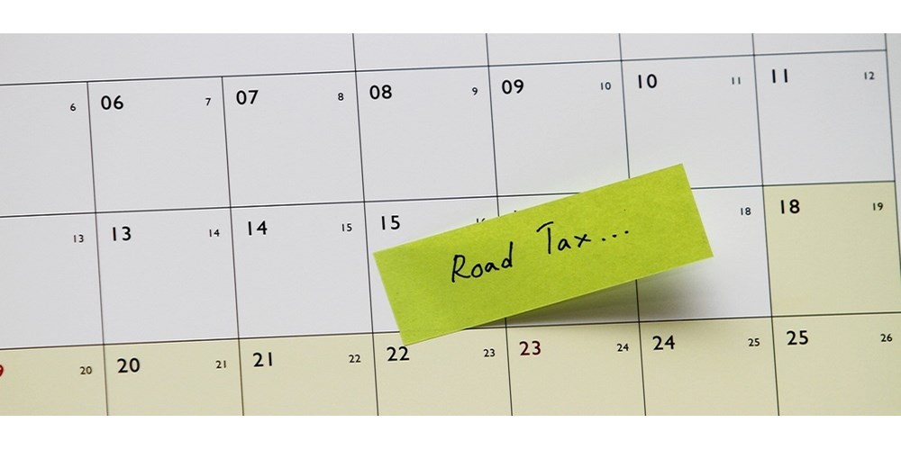 A calendar with a post it note saying "road tax"