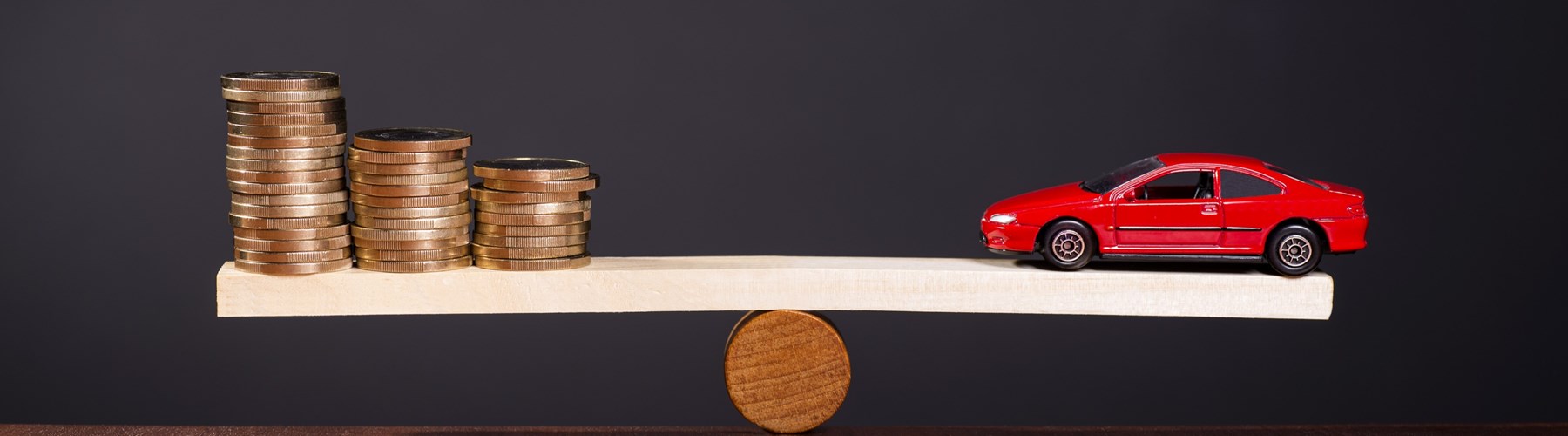 Toy car and coins on a scale