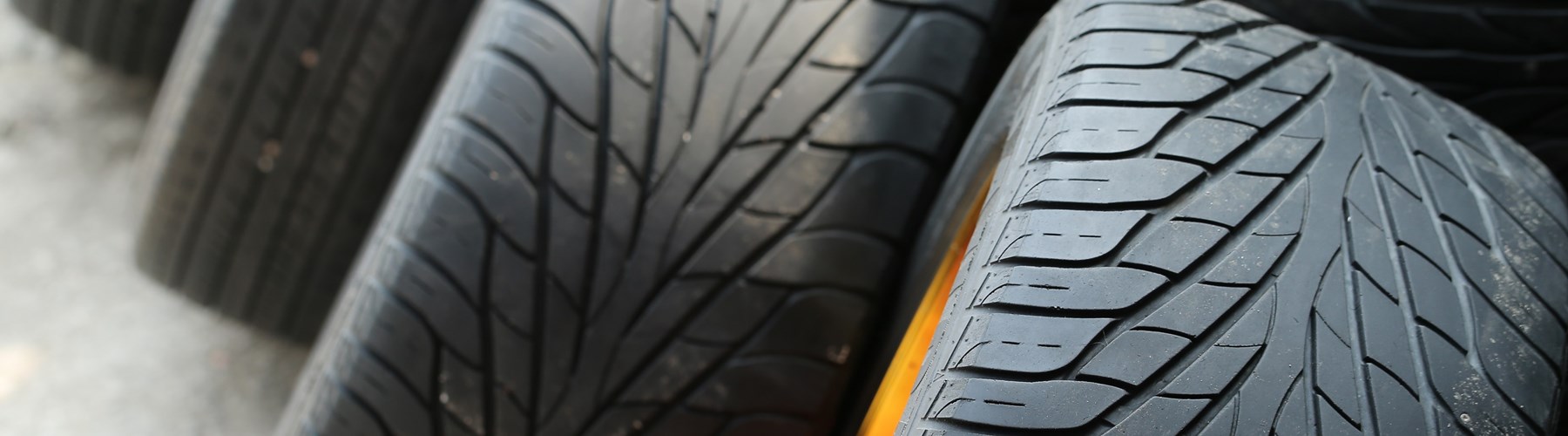 Pile of car tyres with yellow alloys