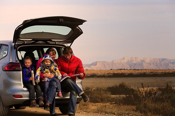 Man with children looking at boot in car boot